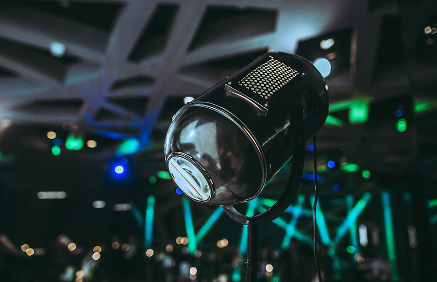 designerlampen_palais-berg - Palais Wertheim Wien Retro studio microphone on a stand in a dim venue with green and blue stage lights