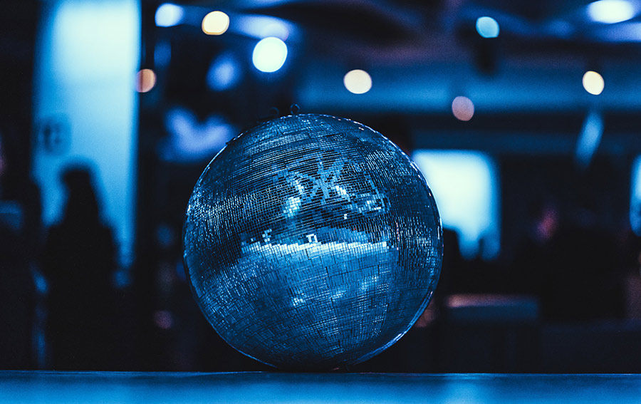 discokugel_palais-berg - Palais Wertheim Wien Blue disco ball reflecting blue lights in a dim party venue on a table surface