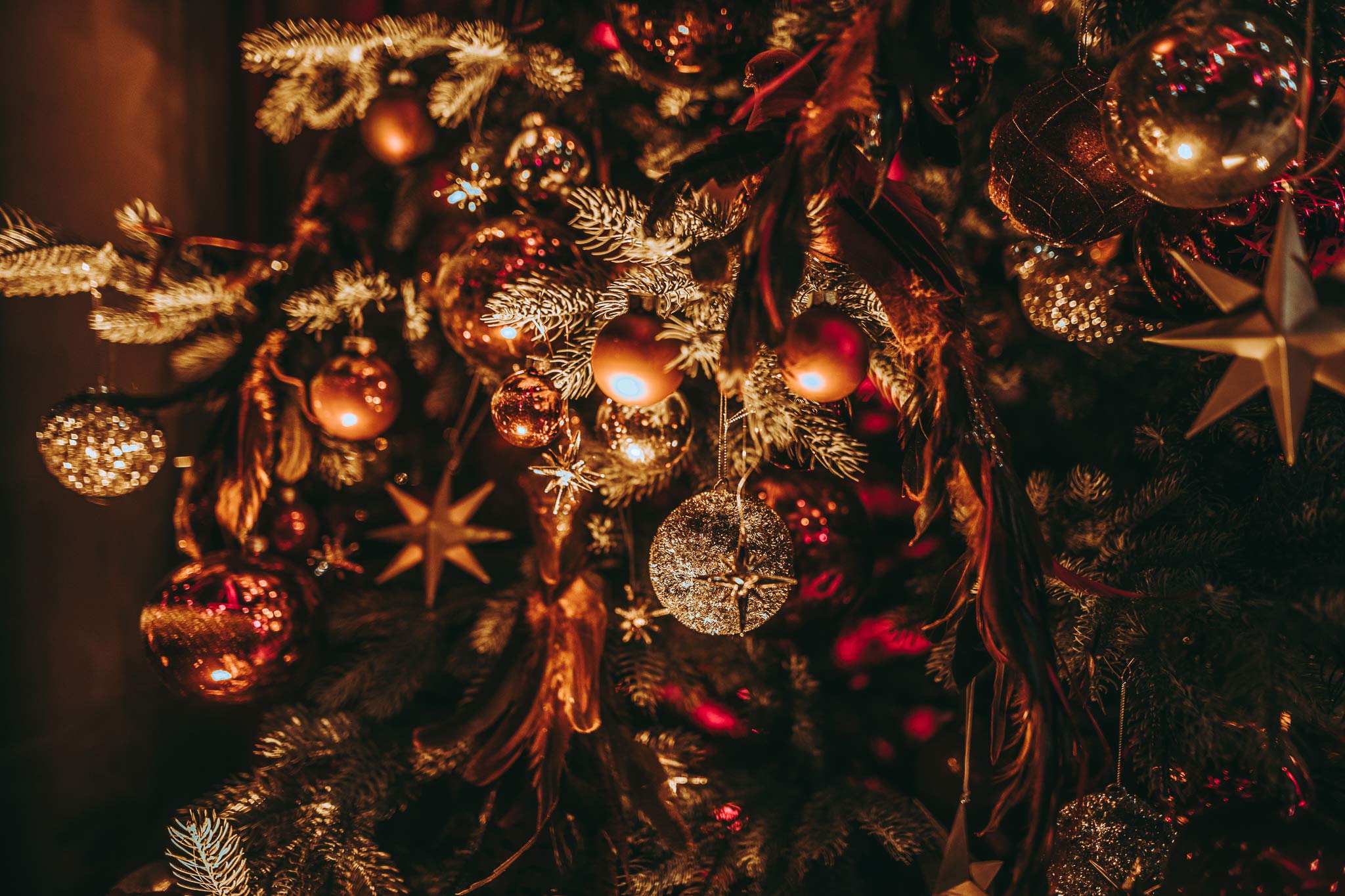 palais-wertheim_weihnachtsdekoration-3 - Palais Wertheim Wien Close-up of a Christmas tree with gold and red ornaments and warm lights.