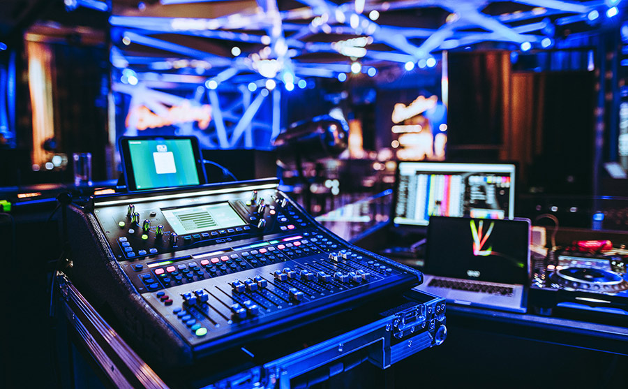 regiepult_palais-berg - Palais Wertheim Wien DJ mixing console with illuminated controls and a laptop in a blue-lit nightclub booth