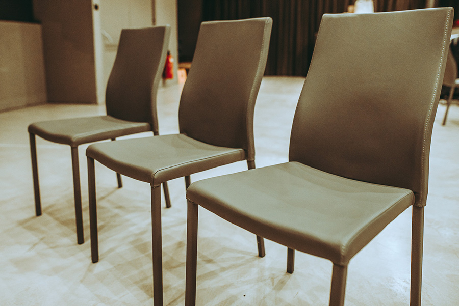 sesse-palais-berg - Palais Wertheim Wien Three brown upholstered chairs lined up in a modern indoor room, viewed from the front-left angle.